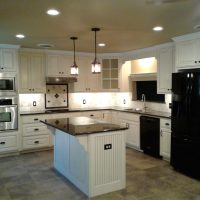 User comments Modern kitchen with white cabinets, black appliances, tile floor, center island, and pendant lights over the island.
