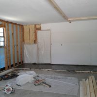 User comments Partially finished garage interior with exposed wall insulation and construction materials on the floor.