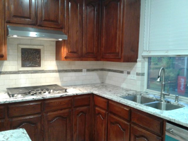 User comments Kitchen with dark wood cabinets, granite countertops, a gas cooktop, and a double sink beneath a window with blinds.